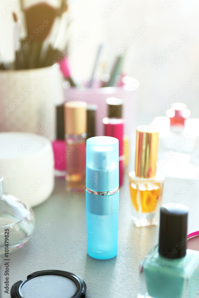 Perfume bottle with makeup tools and cosmetics on a table Perfume bottle with makeup tools and cosmetics on a table