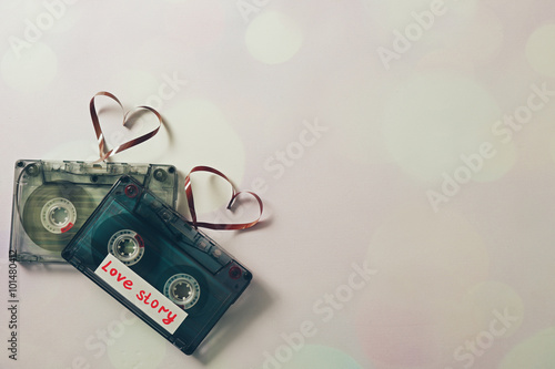 Retro audio cassettes with tapes in shape of hearts on white background