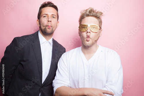 Zwei coole Typen posieren vor rosa Hintergrund