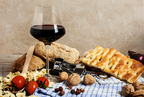 italian food and red wine glass with corkscrew