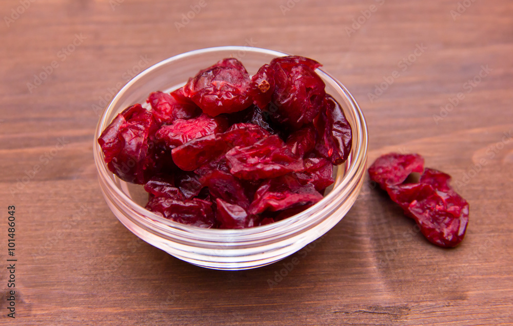 Dried cranberries on bowl on wooden table Dried cranberries on bowl on wooden table