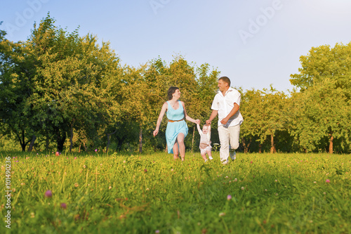 Family and Relationships Concepts. Happy Young Family Running Together Outdoors
