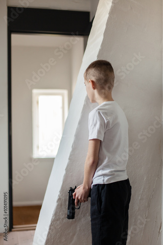 Boy Holding Gun Waiting Someone Behind the Wall