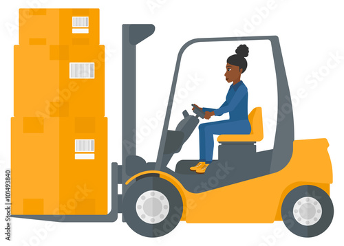 Worker moving load by forklift truck.