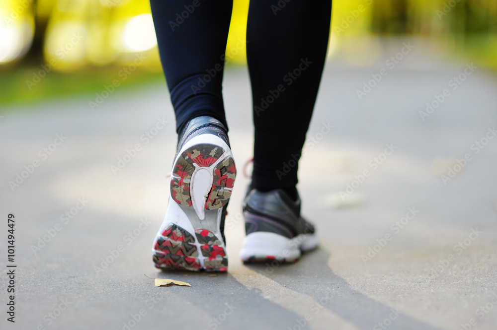Runner feet running on road closeup on shoe Runner feet running on road closeup on shoe