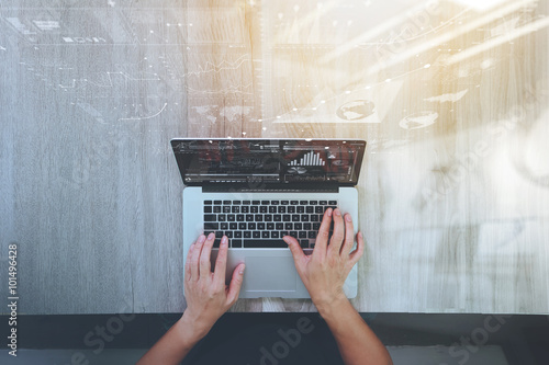 Designer hand working with laptop computer on wooden desk as res photo