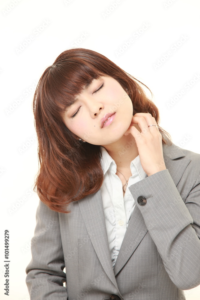 young Japanese businesswoman scratching her neck young Japanese businesswoman scratching her neck