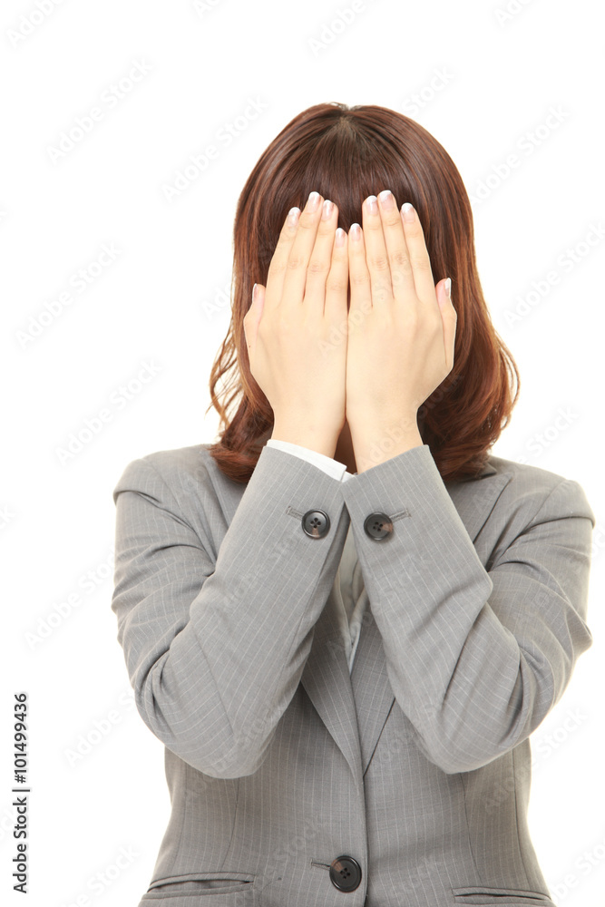 young Japanese businesswoman covering her face with hands 