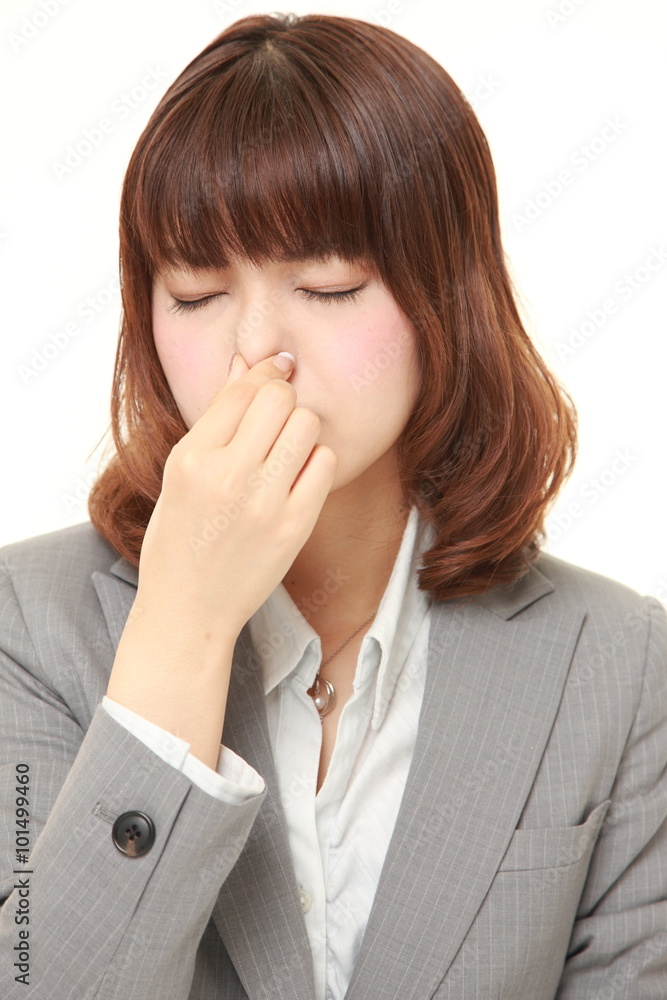 Japanese businesswoman holding her nose because of a bad smell Japanese businesswoman holding her nose because of a bad smell