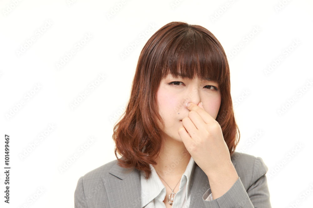 Japanese businesswoman holding her nose because of a bad smell Japanese businesswoman holding her nose because of a bad smell