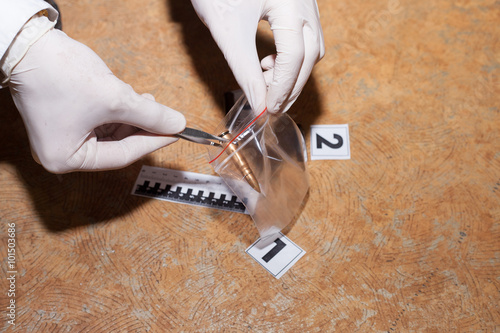 Fotografía Expert examines a bullet at the crime scene