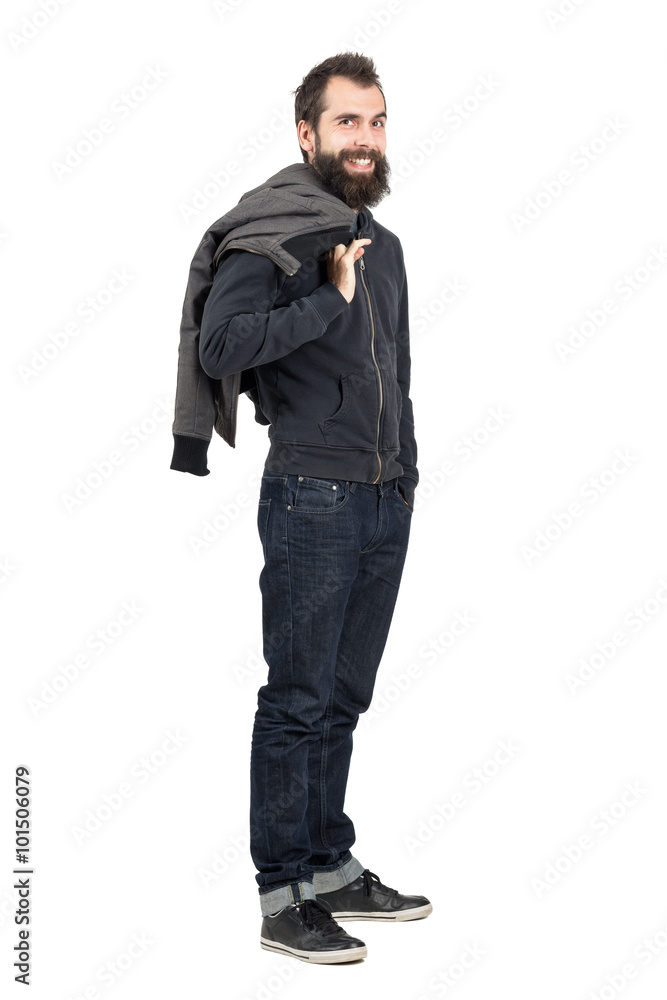 Laughing hipster with smiley piercing in upper lip holding jacket over the shoulder. Full body length portrait isolated over white studio background. Laughing hipster with smiley piercing in upper lip holding jacket over the shoulder. Full body length portrait isolated over white studio background.