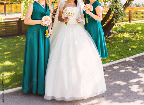 Bride, row of bridesmaids with bouquets at big wedding ceremony. 