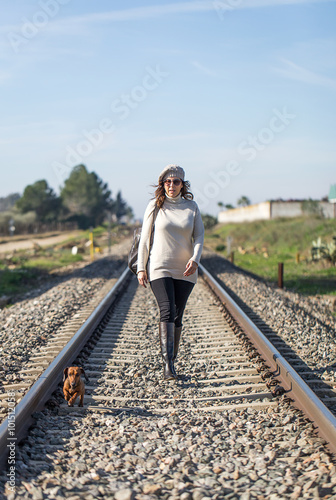 Woman walking along the railway with dog