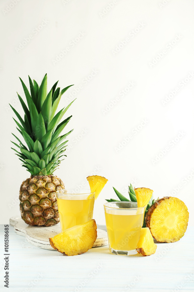 Glasses of pineapple juice on a white wooden table Glasses of pineapple juice on a white wooden table