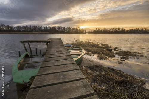 boat moored to a wooden bridge in winter