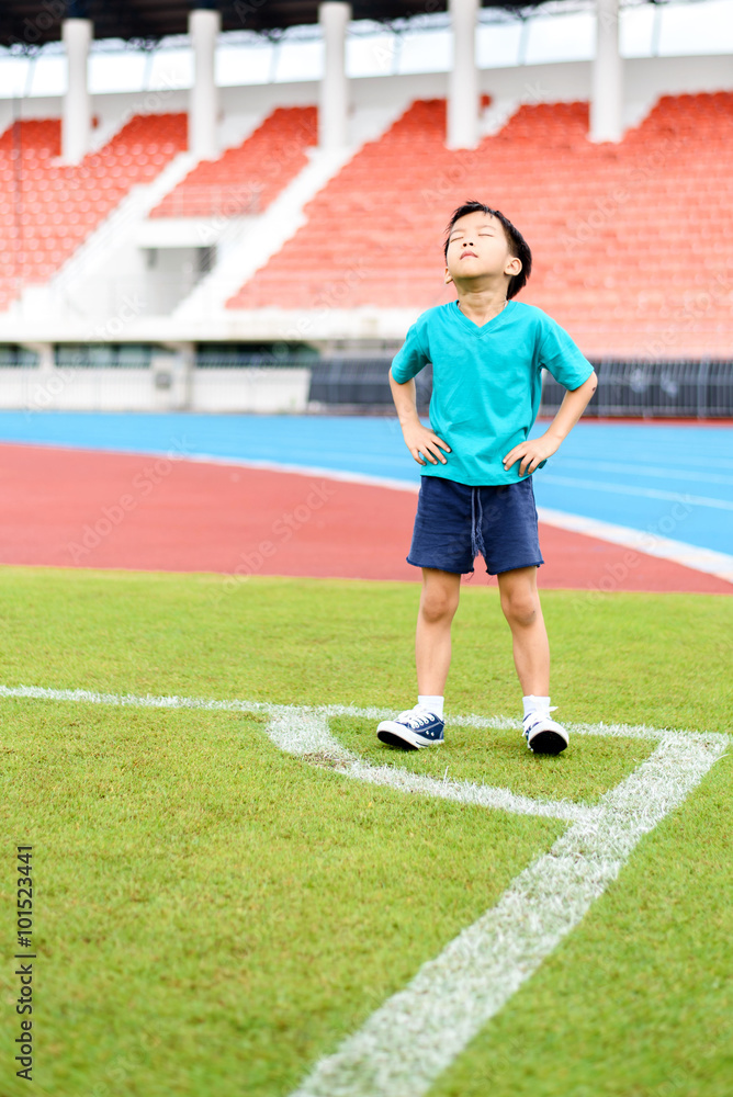 Fototapeta premium Boy stand on the football field.