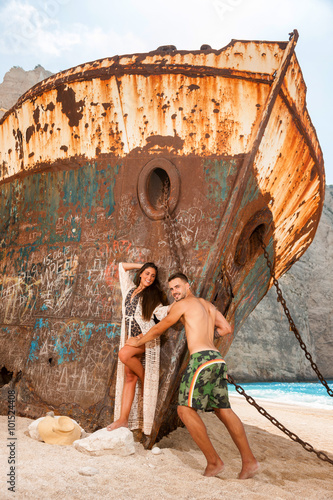 young couple in a beach with shipwreck