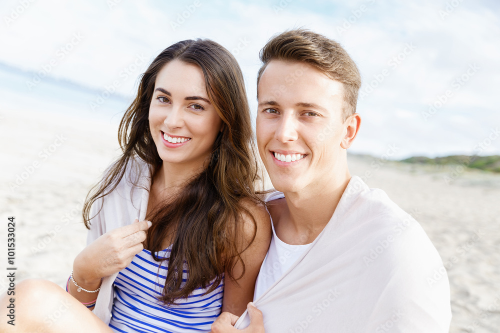 Romantic young couple sitting on the beach