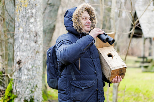 Ornithologist with binoculars and bird cage in the park
 photo