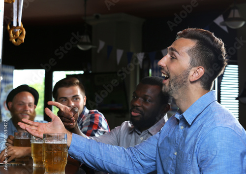Young men drinking beer in pub