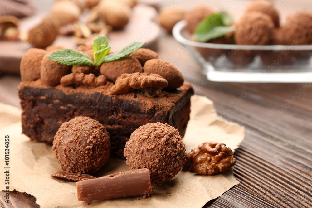 A piece of chocolate cake with walnut and mint on the table, close-up A piece of chocolate cake with walnut and mint on the table, close-up