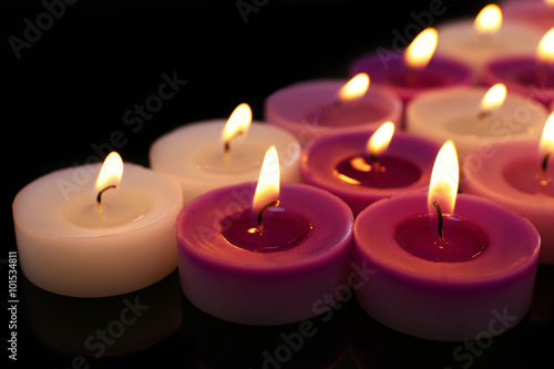 Many burning small candles on dark background  close-up