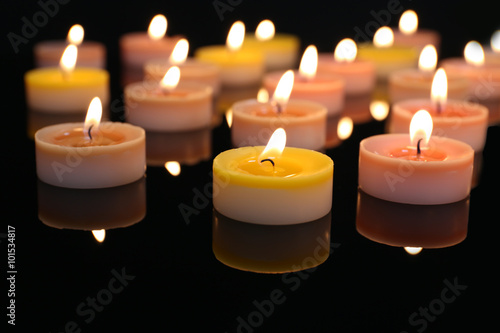 Many burning small candles on dark background