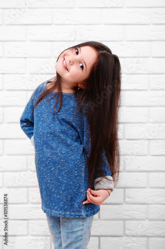 Little girl on a white bric...