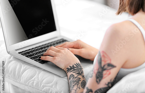 Woman sitting on the sofa with the laptop  closeup