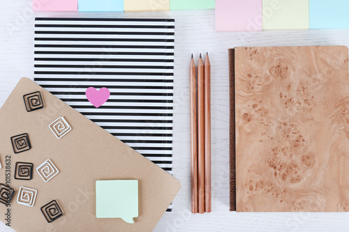 Notebooks with clips, stickers and pencils on a white table