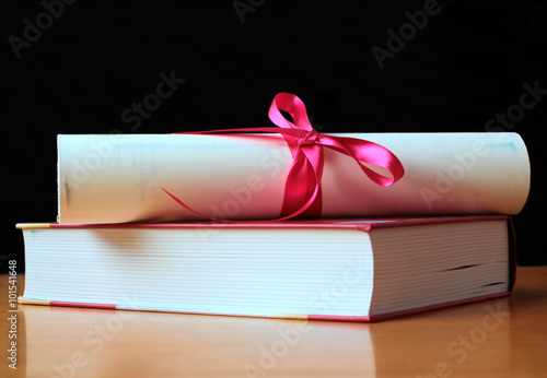 University diploma on book