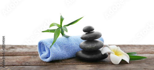 Spa stones with towel, bamboo and tropical flower on white  background