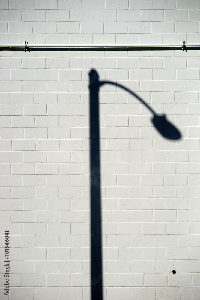 Laternenschatten auf Mauerwand / Ein markant gebogener Laternenschatten auf einer gemauerten Wand. Laternenschatten auf Mauerwand / Ein markant gebogener Laternenschatten auf einer gemauerten Wand.