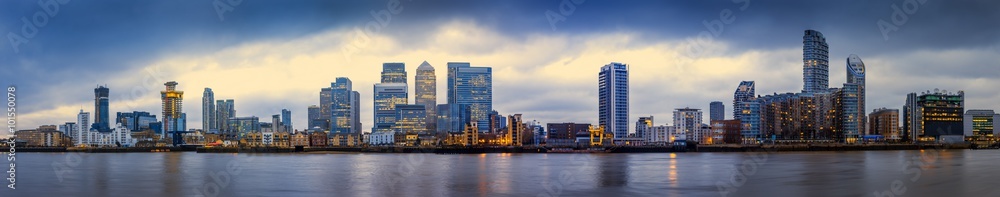 Wide panoramic skyline of Canary Wharf, the worlds leading financial district at blue hour - London, UK
