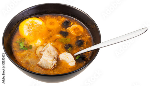 russian Solyanka fish soup in bowl with spoon
