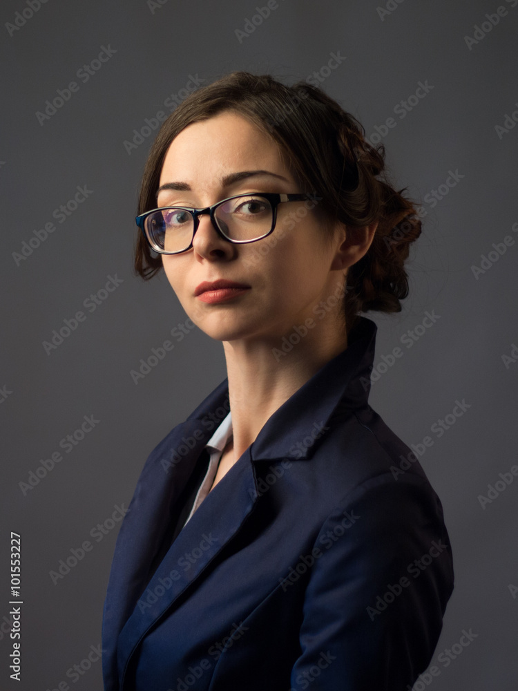 Businesswoman in glasses  on a gray background