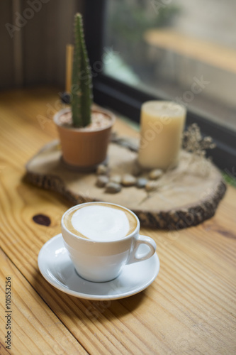 A cup of hot cappuccino in wood table