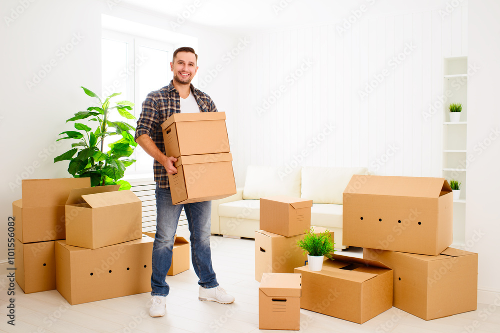 moving to a new apartment. happy man with cardboard boxes moving to a new apartment. happy man with cardboard boxes