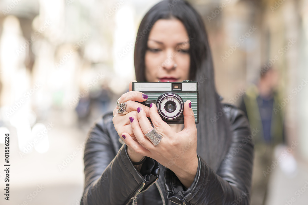 Hipster woman taking pictures with classica camera.