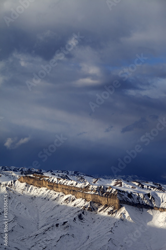 Sunlight winter mountains and storm clouds at evening. photo