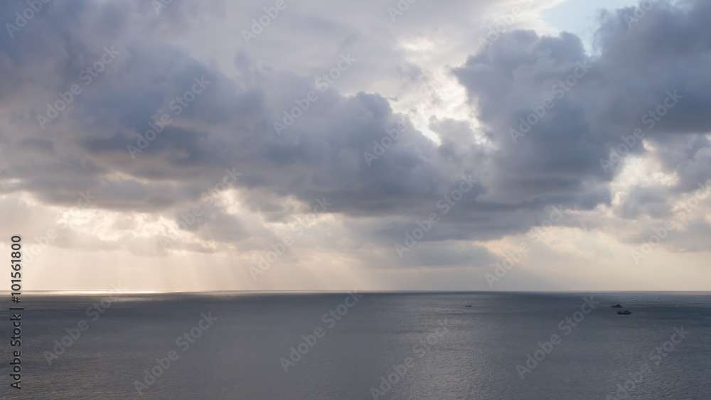 Beautiful seascape with sunbeams shine through cloudy sky