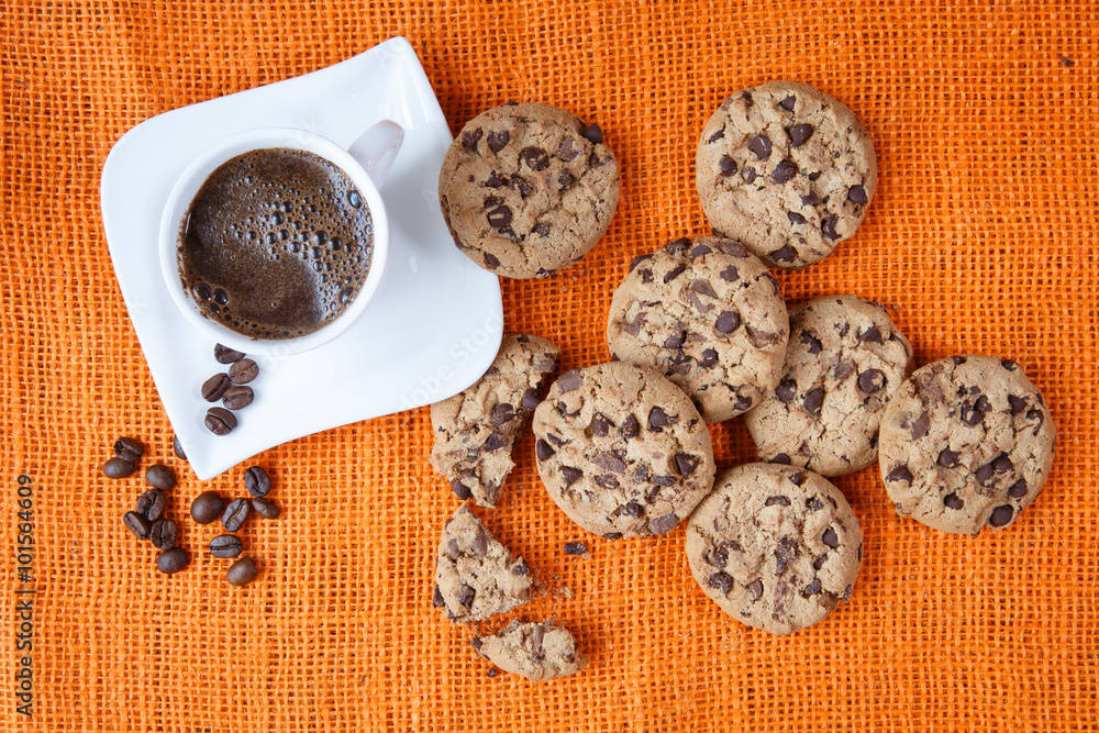 Chocolate chip cookies and cup of coffee shot on jute colored cl Chocolate chip cookies and cup of coffee shot on jute colored cl