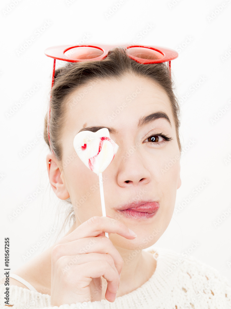 Φωτογραφία Portrait of a young woman with a heart shaped lollipop infront of her face