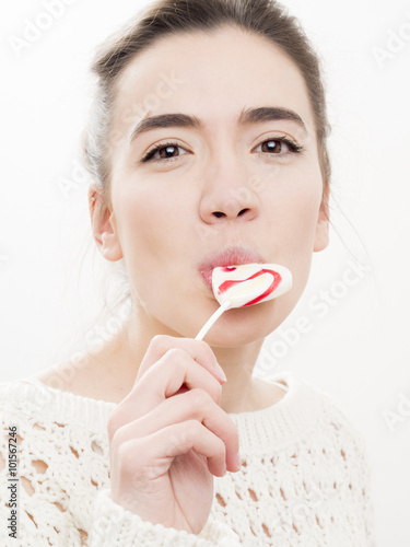 Portrait of a young woman with a lollipop. Isolated on white. Beauty shot, close up.