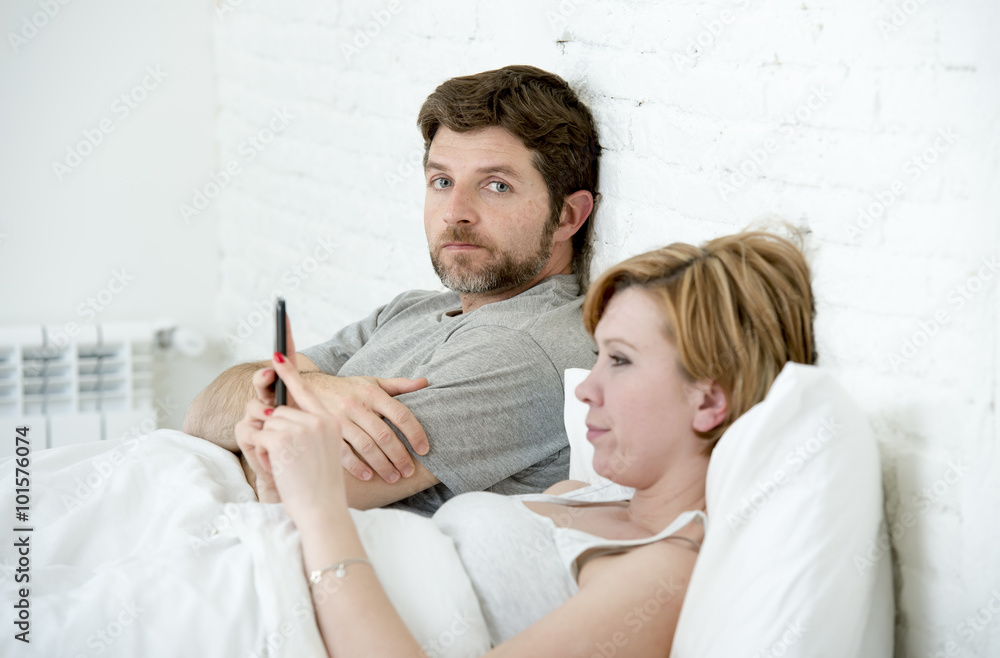 couple in bed husband frustrated upset unsatisfied while wife using mobile phone couple in bed husband frustrated upset unsatisfied while wife using mobile phone
