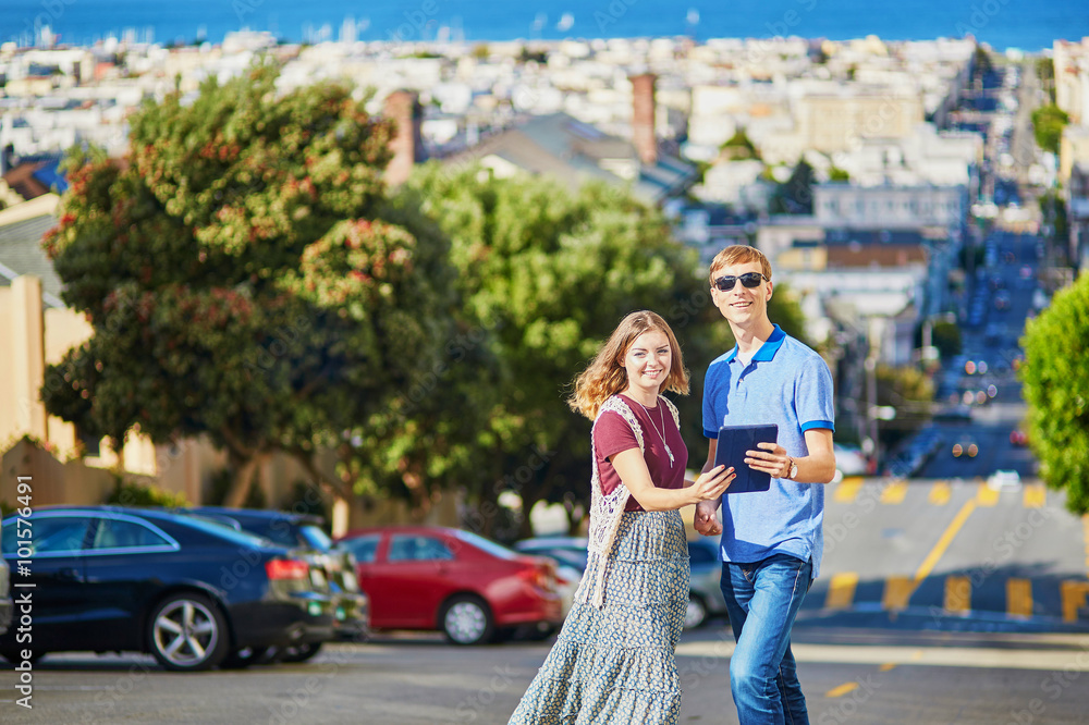 Obraz premium Romantic couple of tourists using tablet in San Francisco, California, USA