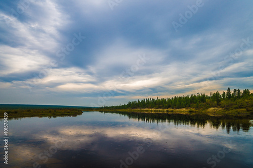 Summer day landscape with river and forest and cloudy sky 