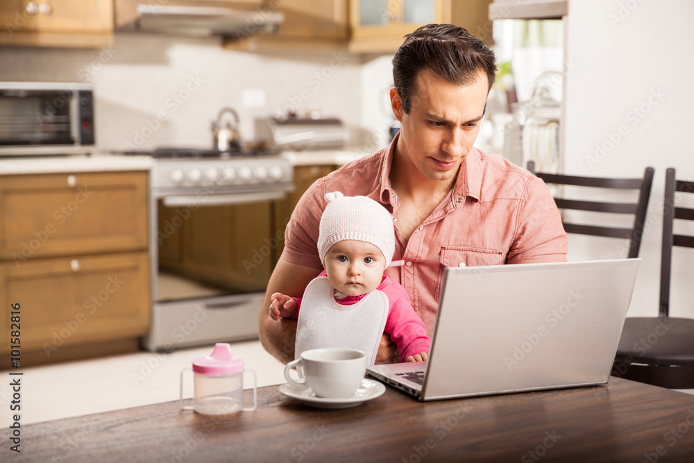 Young single dad working at home with his baby Young single dad working at home with his baby