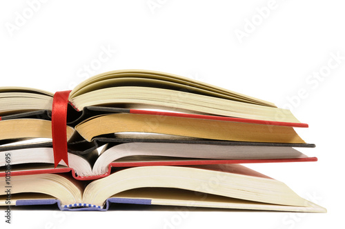 Small pile of open book with red bookmark ribbon isolated on white background school college studying photo